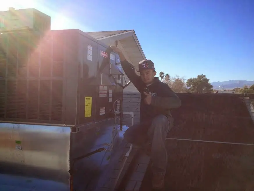 HVAC technician performing AC Tune-Up on a rooftop unit in Cibolo